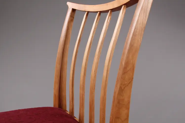 Chair slats are bent, laminated pieces which allow some give. They are each shaped by hand.